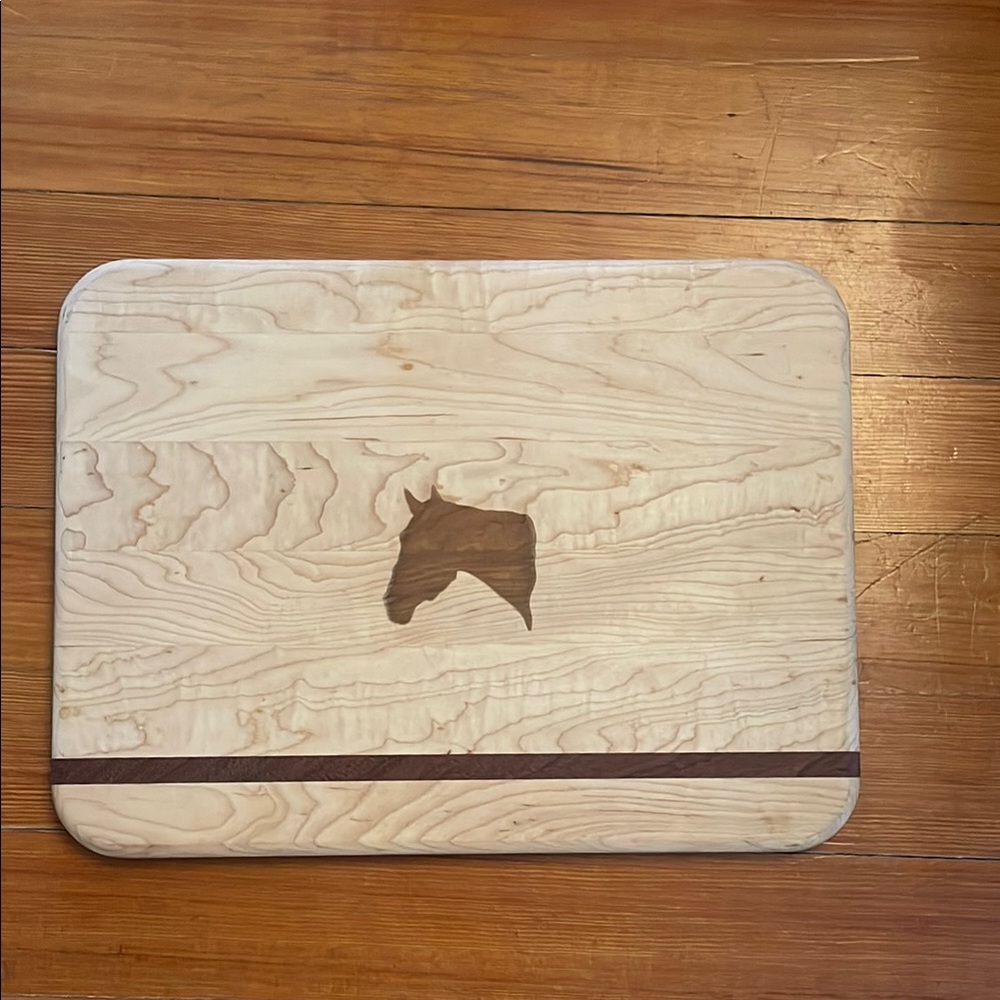 Maple cutting board with mahogany accent strip and horse motif